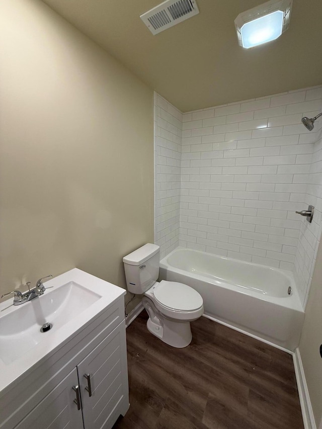 full bathroom featuring hardwood / wood-style floors, vanity, toilet, and tiled shower / bath