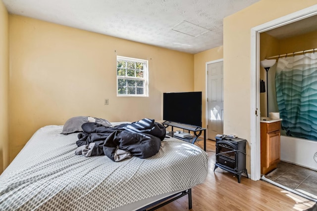 bedroom with a closet, hardwood / wood-style flooring, and a textured ceiling