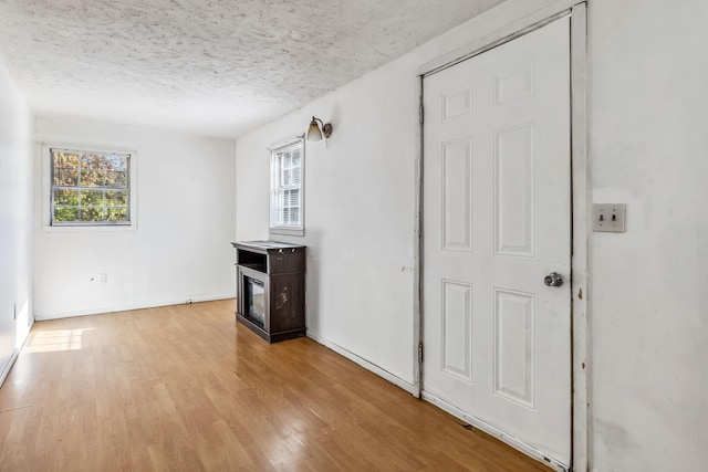 empty room featuring a textured ceiling and light hardwood / wood-style flooring