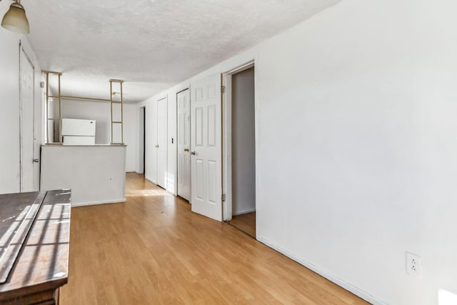 unfurnished room with a textured ceiling and light hardwood / wood-style flooring