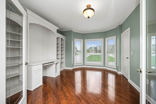 unfurnished living room with built in desk, dark wood-type flooring, and plenty of natural light