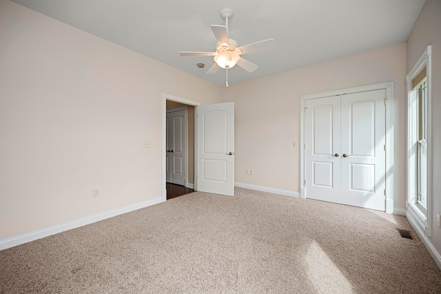 unfurnished bedroom featuring carpet floors, a closet, and ceiling fan