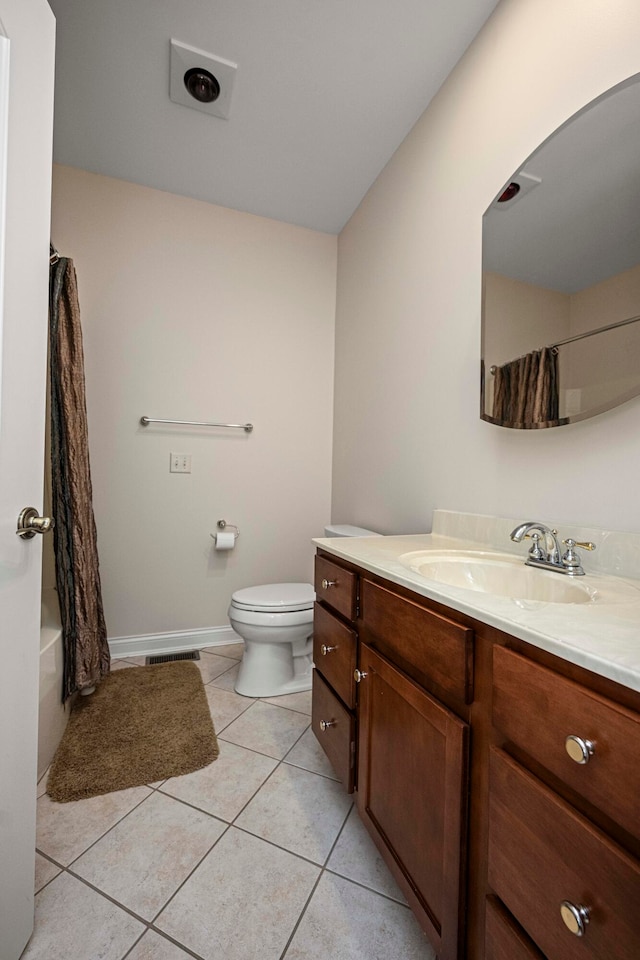 full bathroom with shower / bath combo with shower curtain, tile patterned floors, vanity, and toilet