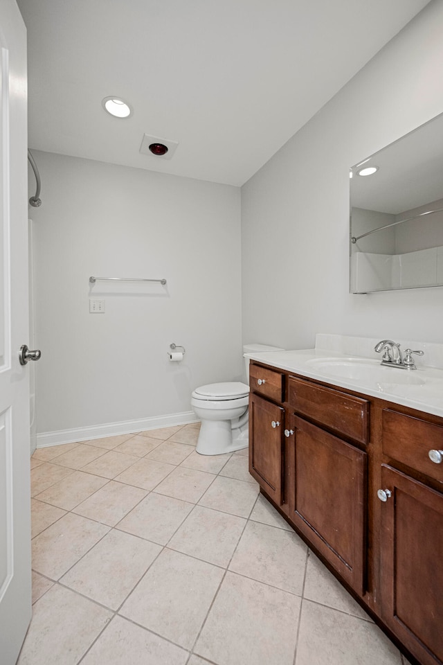 bathroom featuring walk in shower, vanity, tile patterned flooring, and toilet