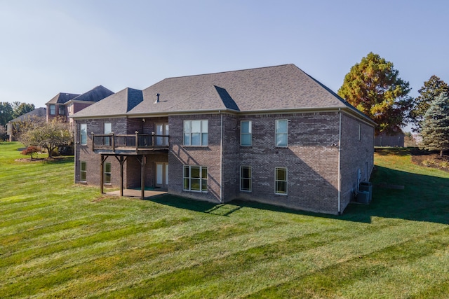 rear view of house with central AC unit and a lawn