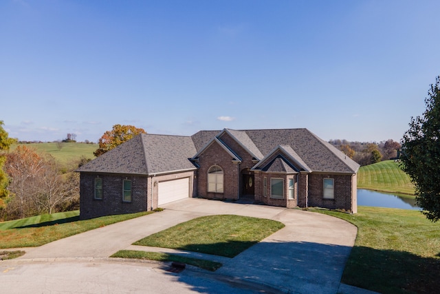 view of front of property featuring a water view, a front yard, and a garage