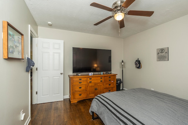 bedroom featuring ceiling fan, dark wood-type flooring, and a textured ceiling