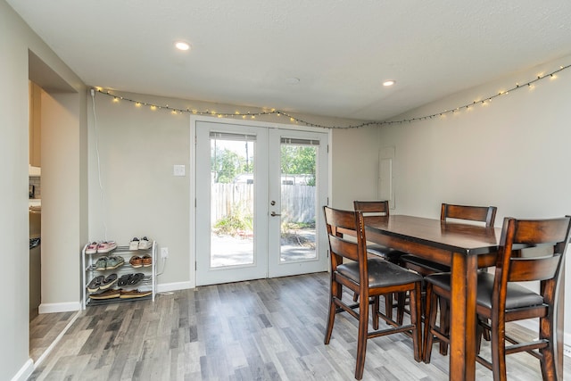 dining room with french doors and light hardwood / wood-style flooring