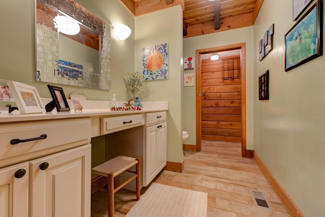 bathroom featuring hardwood / wood-style floors, vanity, toilet, and wood ceiling