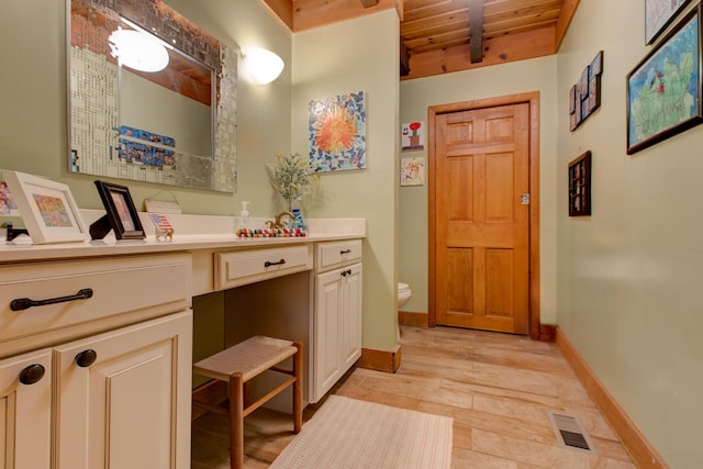 bathroom featuring beamed ceiling, toilet, vanity, wood ceiling, and hardwood / wood-style flooring