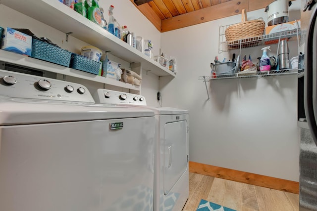 laundry area featuring washer and clothes dryer, wooden ceiling, and light hardwood / wood-style floors