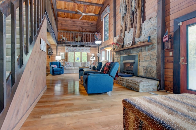 living room with high vaulted ceiling, light hardwood / wood-style flooring, wood walls, and wood ceiling