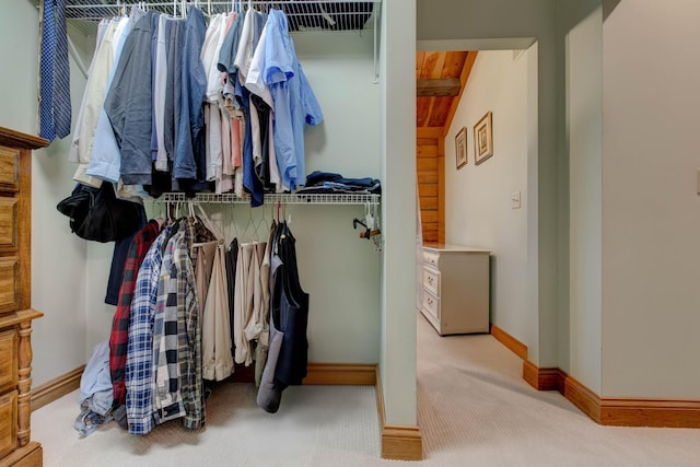 spacious closet with light colored carpet and lofted ceiling