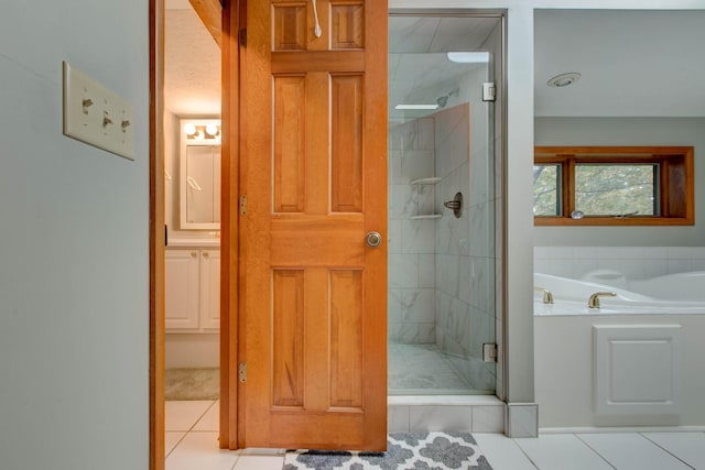 bathroom with tile patterned floors and shower with separate bathtub