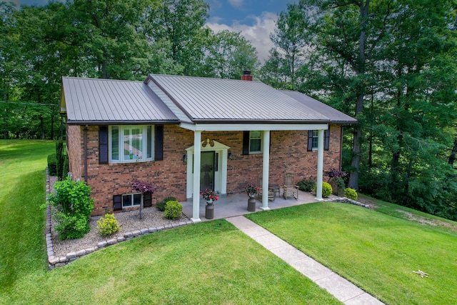 view of front of home with a patio and a front lawn