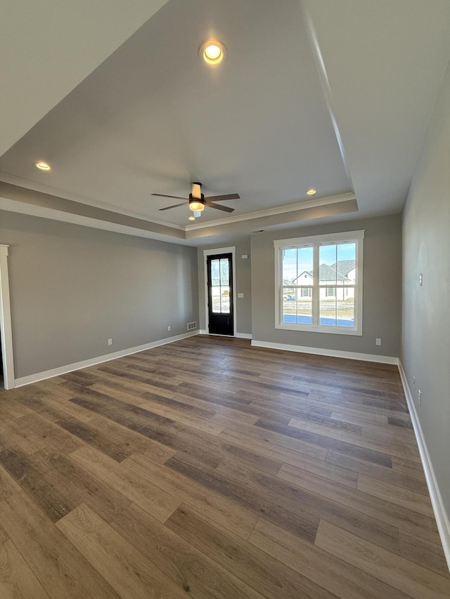 interior space featuring dark hardwood / wood-style floors, a raised ceiling, and ceiling fan