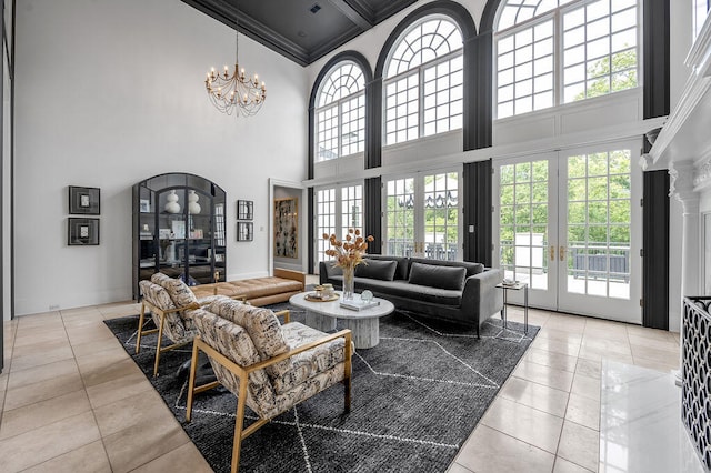 tiled living room featuring beam ceiling, an inviting chandelier, ornamental molding, a high ceiling, and french doors