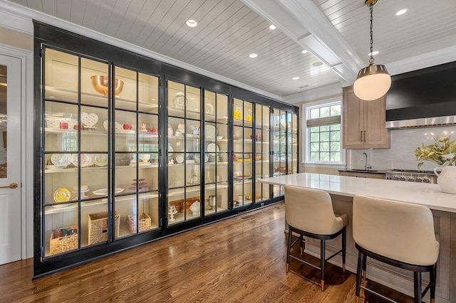 kitchen featuring dark hardwood / wood-style floors, ventilation hood, sink, crown molding, and decorative light fixtures