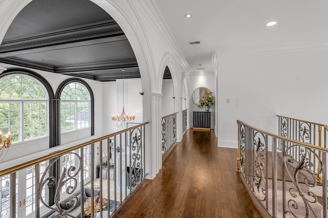 hallway with ornamental molding, dark wood-type flooring, and a notable chandelier