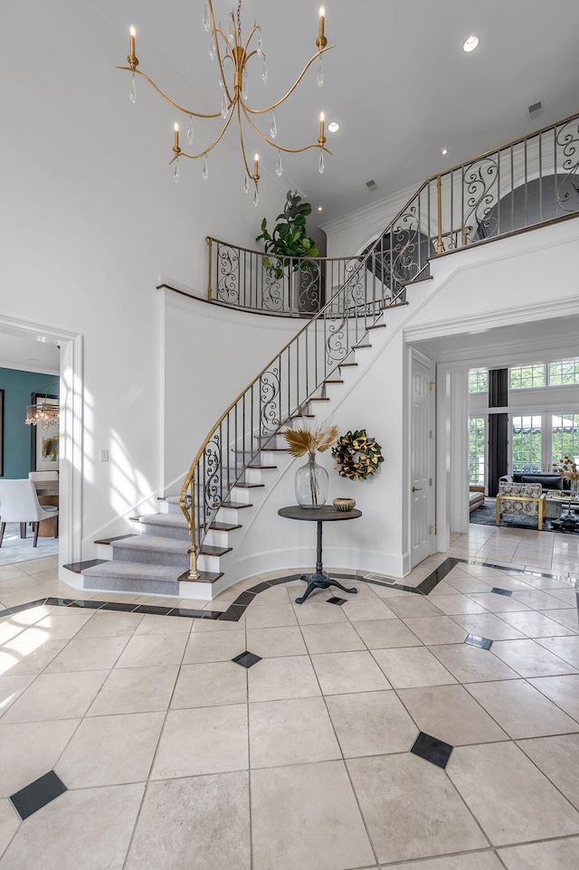 stairs with a notable chandelier, a high ceiling, and tile patterned flooring