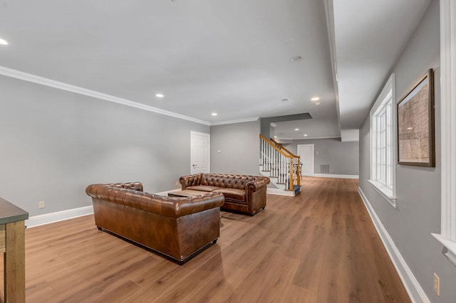 living room with ornamental molding and light hardwood / wood-style flooring