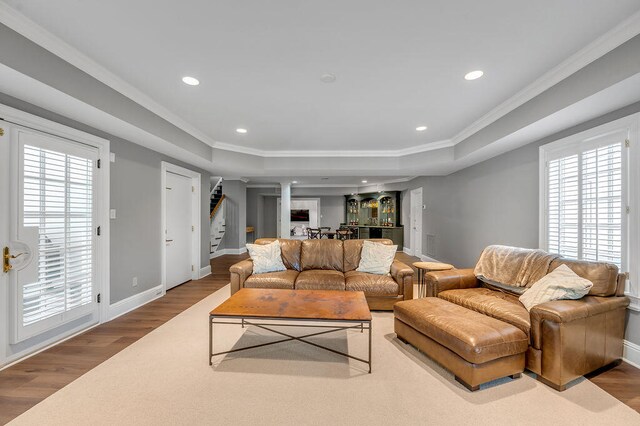 living room featuring a healthy amount of sunlight, hardwood / wood-style flooring, and ornamental molding