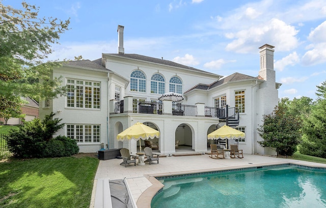 back of house featuring a patio area, a lawn, and a balcony