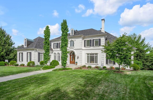 colonial inspired home with a front lawn