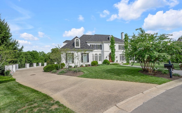 french country home featuring a front lawn