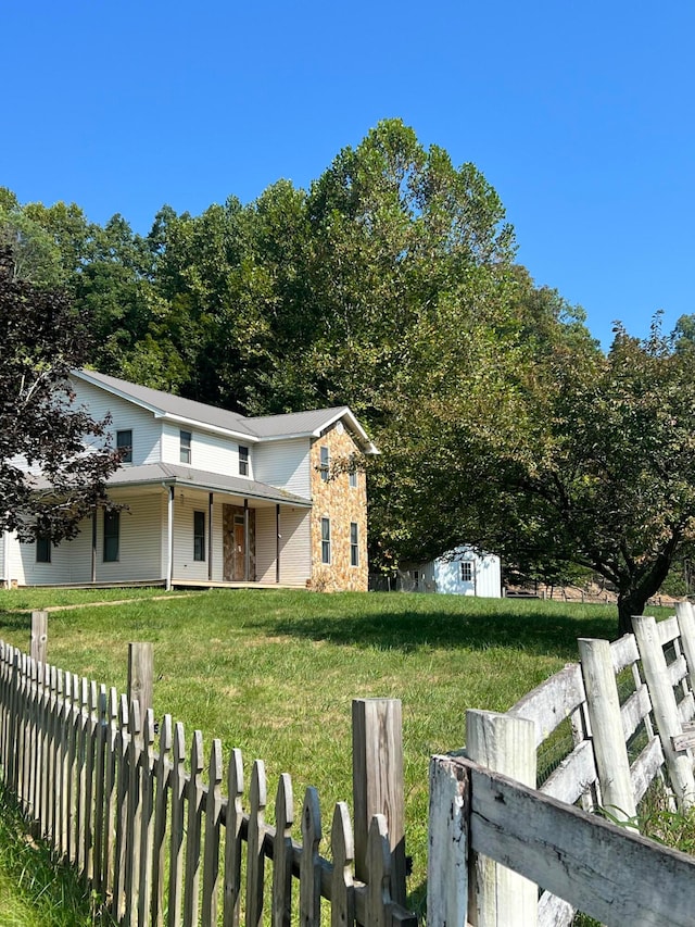 view of front of home with a shed and a front lawn