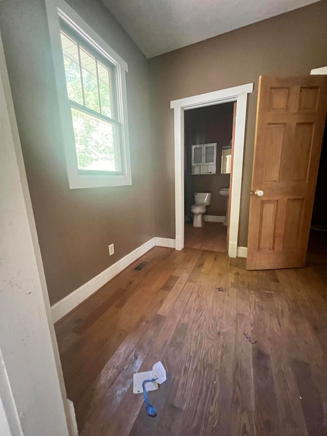 empty room with wood-type flooring and a textured ceiling