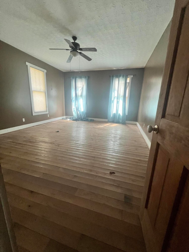 spare room with wood-type flooring, a textured ceiling, and ceiling fan