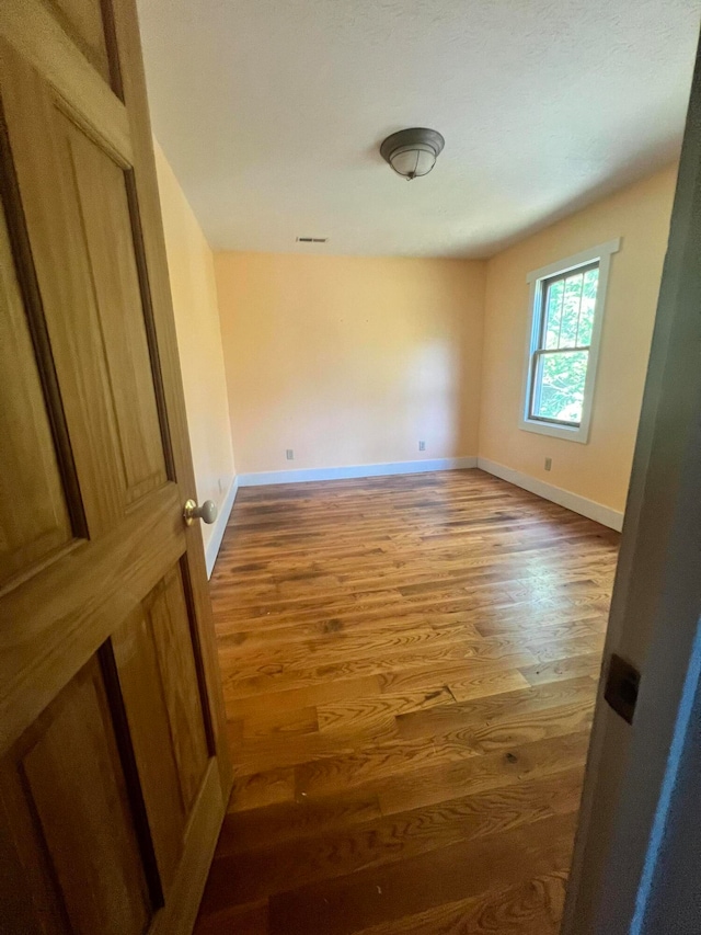 spare room featuring wood-type flooring