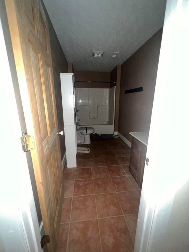 hall featuring dark tile patterned floors