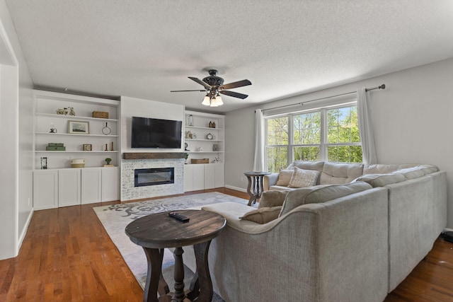 living room featuring dark wood-type flooring, a textured ceiling, and ceiling fan