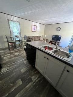 kitchen featuring dishwasher, dark hardwood / wood-style floors, a textured ceiling, and white cabinetry