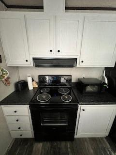 kitchen with extractor fan, black range with electric stovetop, white cabinetry, and dark hardwood / wood-style flooring