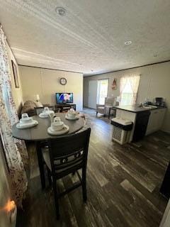 dining room with dark wood-type flooring and a textured ceiling