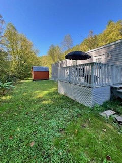 view of yard featuring a shed and a wooden deck