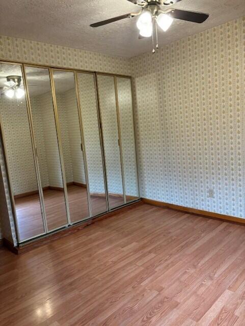 unfurnished bedroom featuring wood-type flooring and a textured ceiling