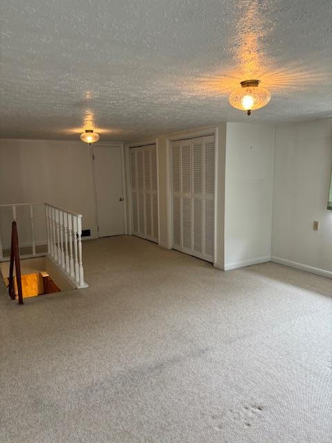 empty room with carpet floors and a textured ceiling