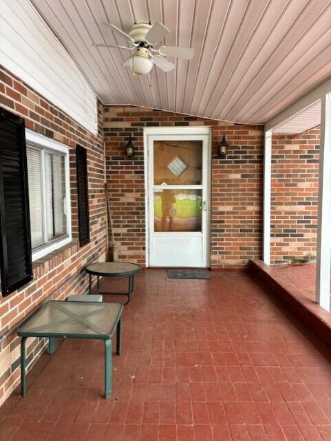 unfurnished sunroom featuring wooden ceiling and ceiling fan