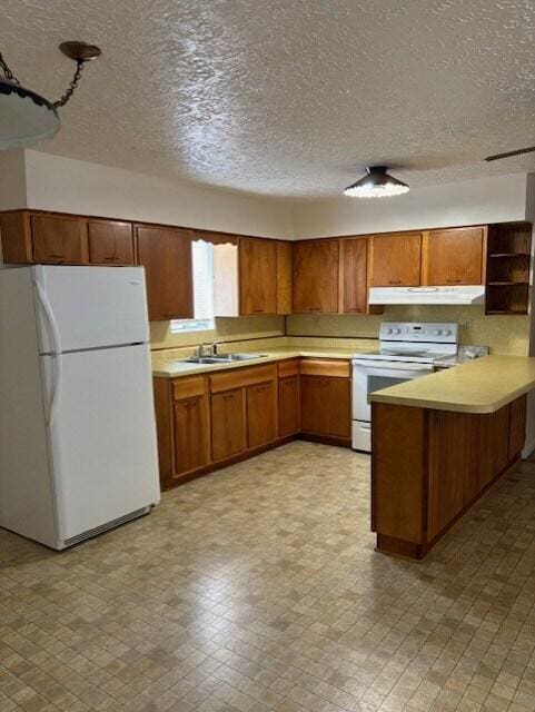 kitchen featuring white appliances, sink, and a textured ceiling