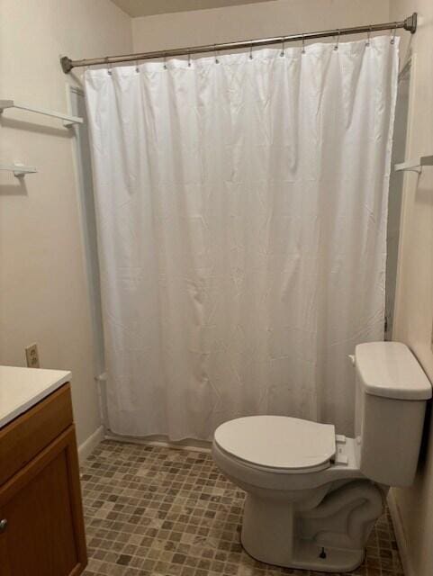 bathroom featuring curtained shower, vanity, and toilet