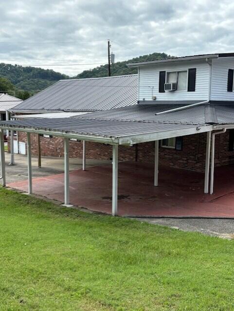 view of car parking with a carport and a lawn