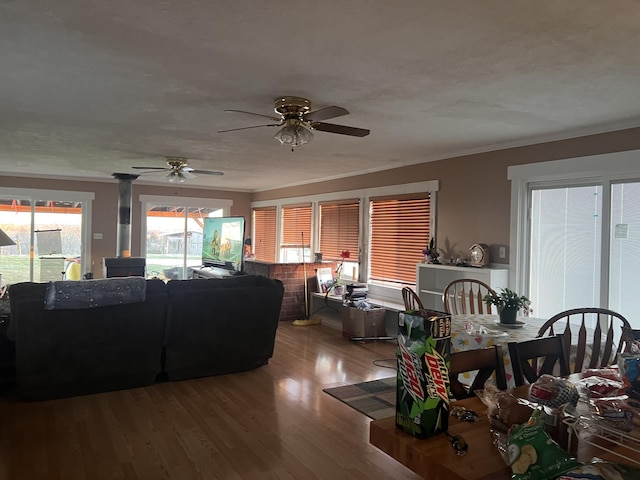 living area with a textured ceiling, ornamental molding, and wood finished floors