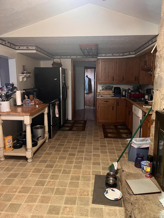 kitchen with dark brown cabinetry, lofted ceiling, sink, and white dishwasher