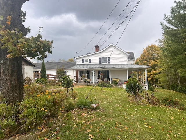 farmhouse featuring covered porch and a front yard