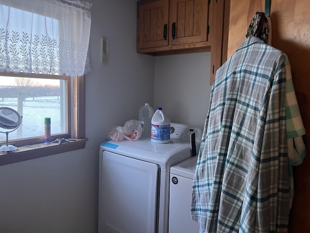 clothes washing area featuring washer and clothes dryer and cabinet space