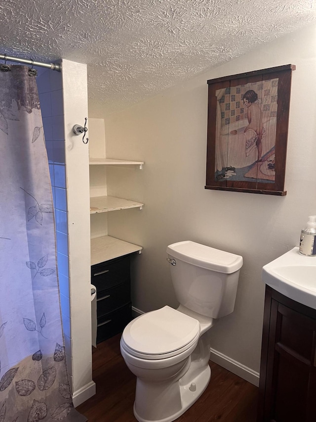 bathroom featuring vanity, hardwood / wood-style floors, a textured ceiling, and toilet